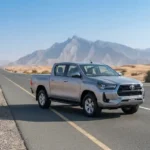 Used Toyota Hilux pickup truck parked on a UAE highway